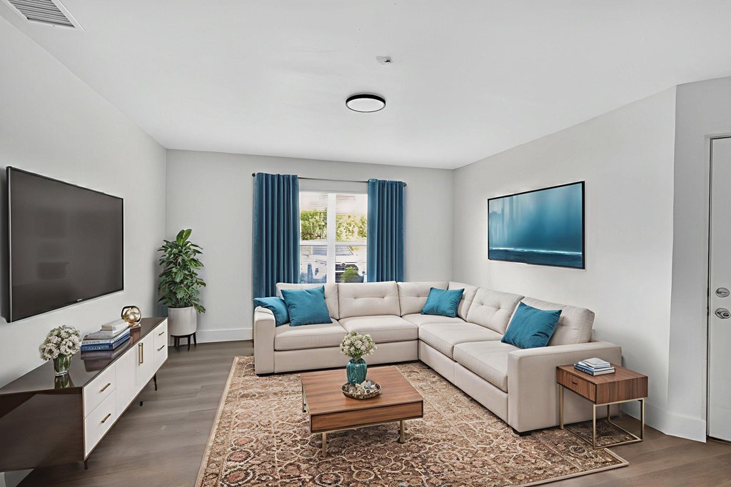 A living room with a white couch and a television.