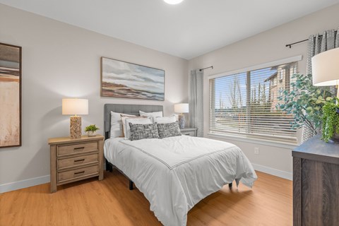 Bedroom with neutral decor and large window at The Residences at Stone Creek Apartments, Washington, 98354
