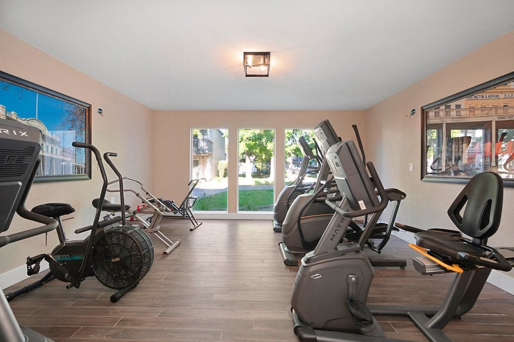 a gym with cardio equipment and a large window with a view of the street at Citrus Heights Apartments, California, 95621