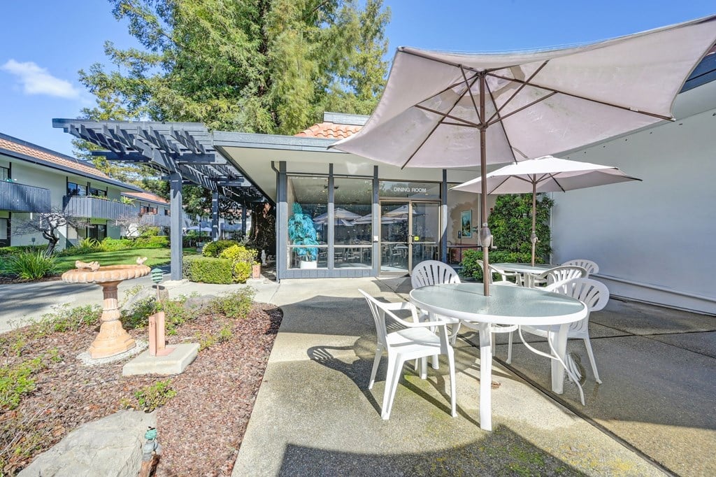a patio with a table and chairs and an umbrella