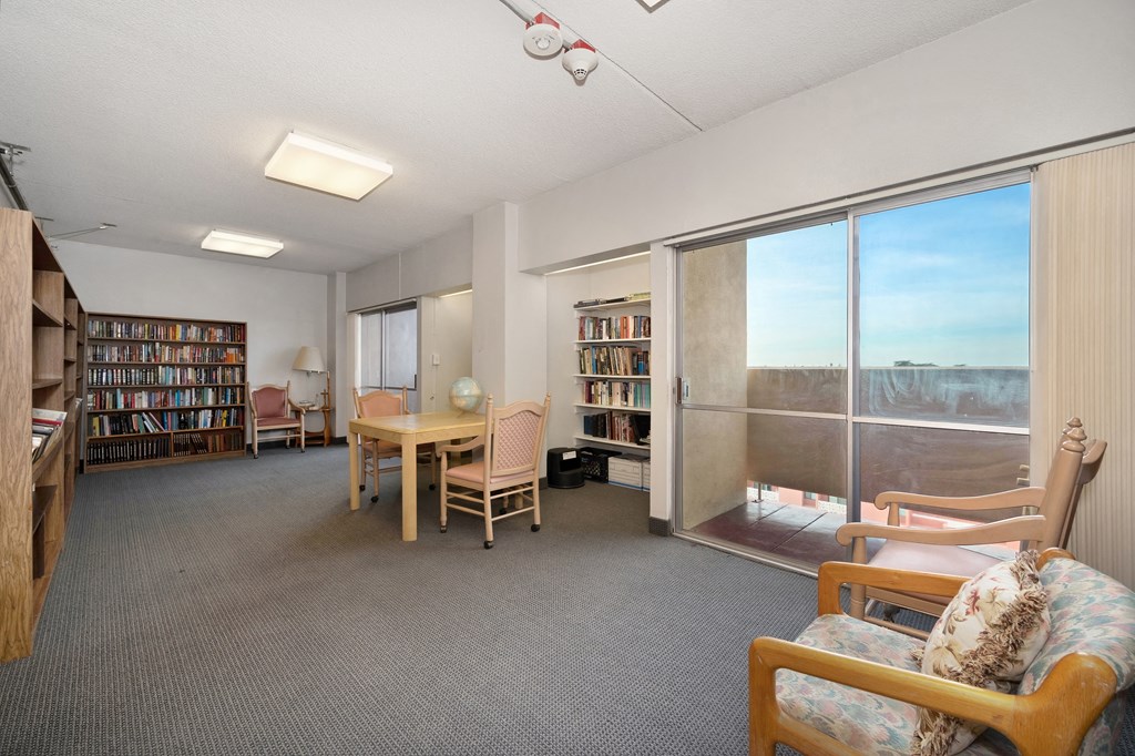 a living room with a table and chairs and a large window