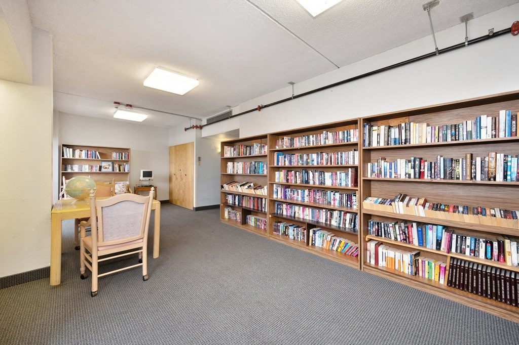 a library with a table and chairs and shelves of books