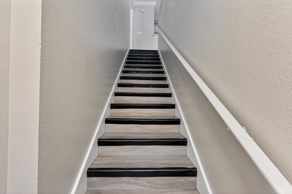 A staircase with wooden steps and white railings.