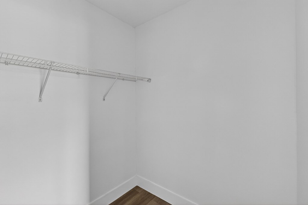 A white wall with a metal rack on it.