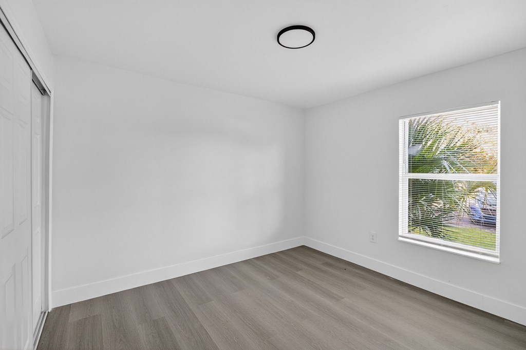 A room with a painting on the wall and a white door.