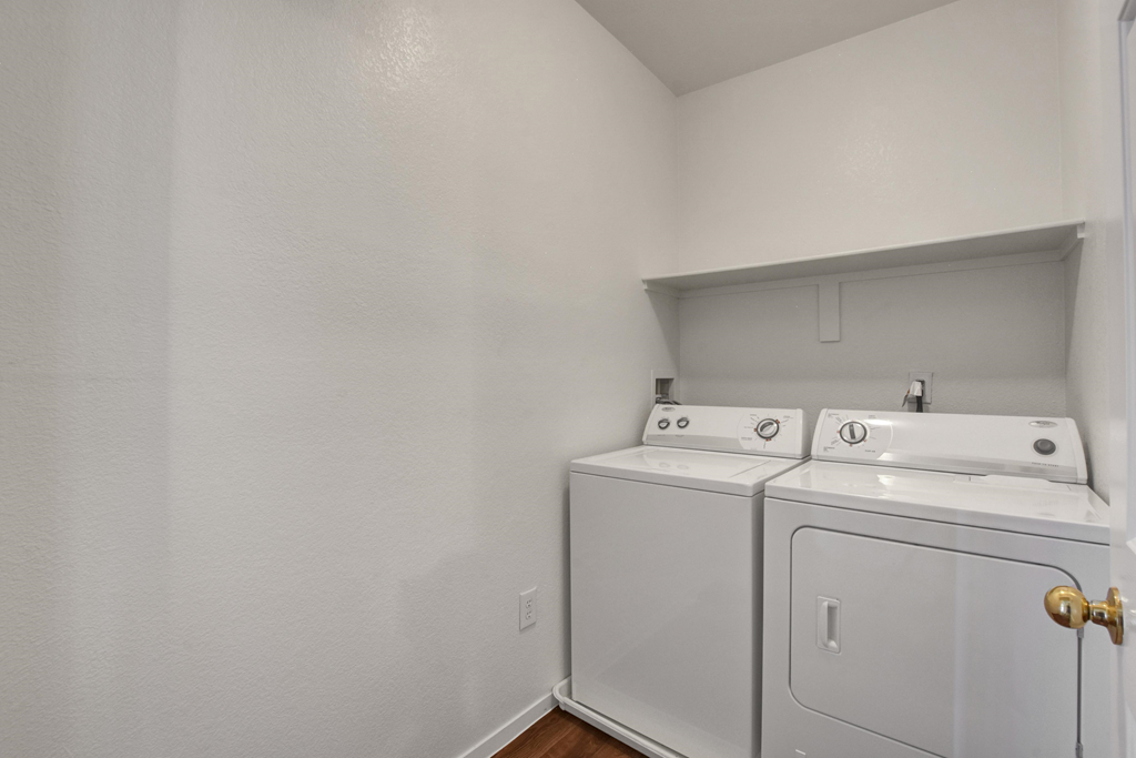 an empty room with a washer and dryer in it and a white wall