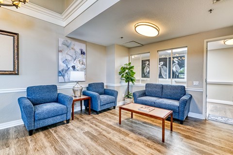 A living room with blue chairs and a wooden coffee table.