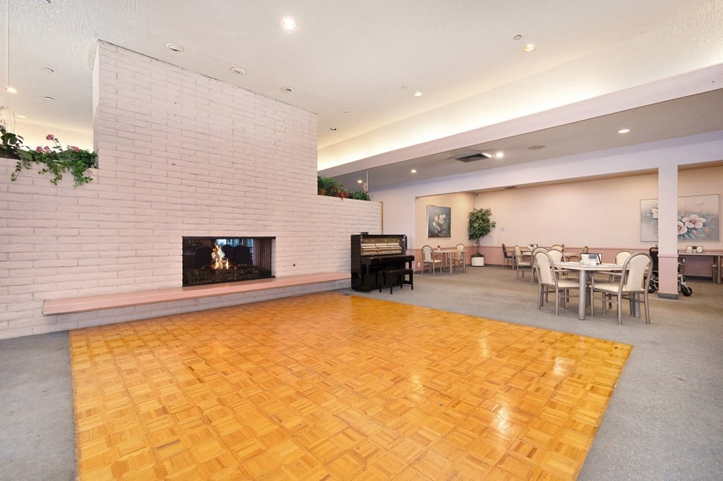 a large room with a fireplace and tables and chairs
