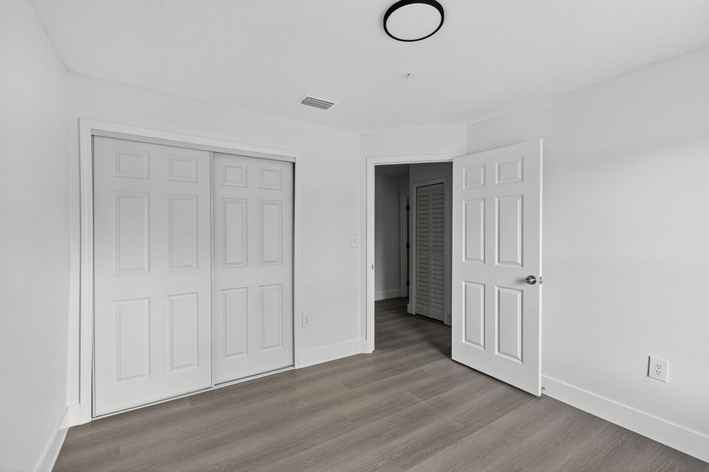 A room with a white door and a white ceiling light.