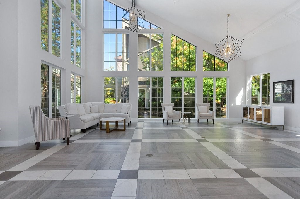 a large living room with large windows and a checkered tile floor