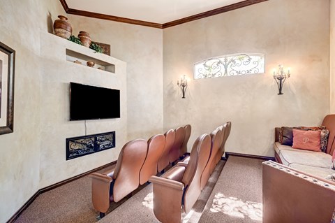A living room with a fireplace and a row of chairs.