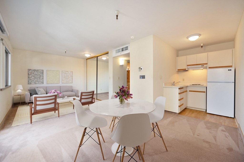 a living room with a table and chairs and a kitchen