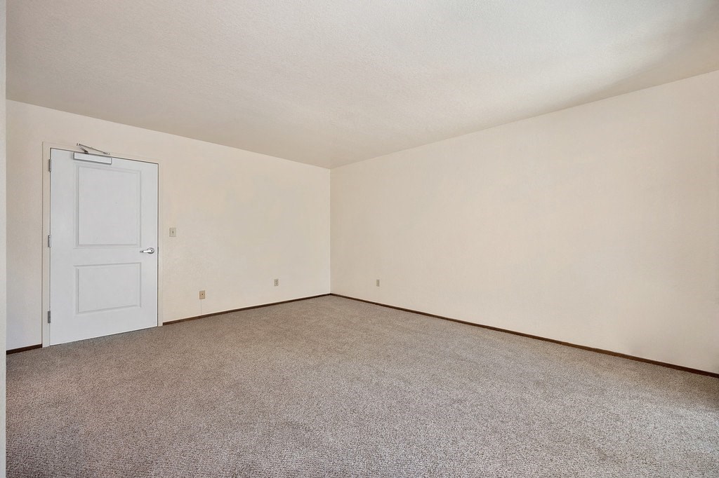 a bedroom with beige carpet and a white door