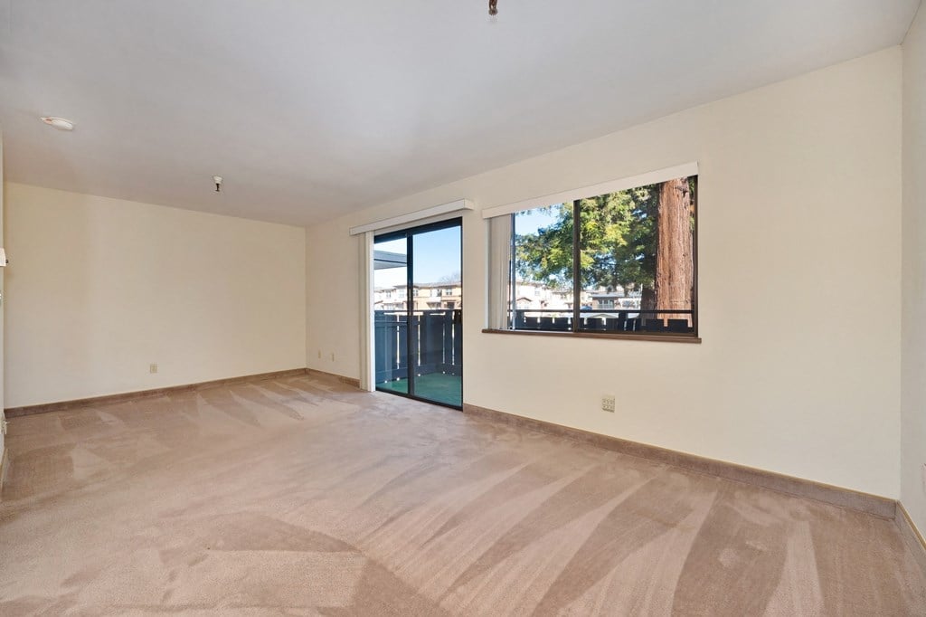 a living room with a large window and a door to a balcony