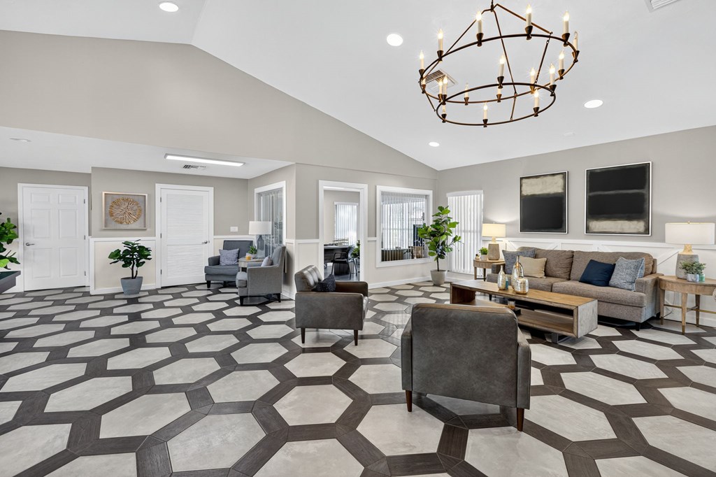 A spacious living room with a patterned floor and a chandelier.