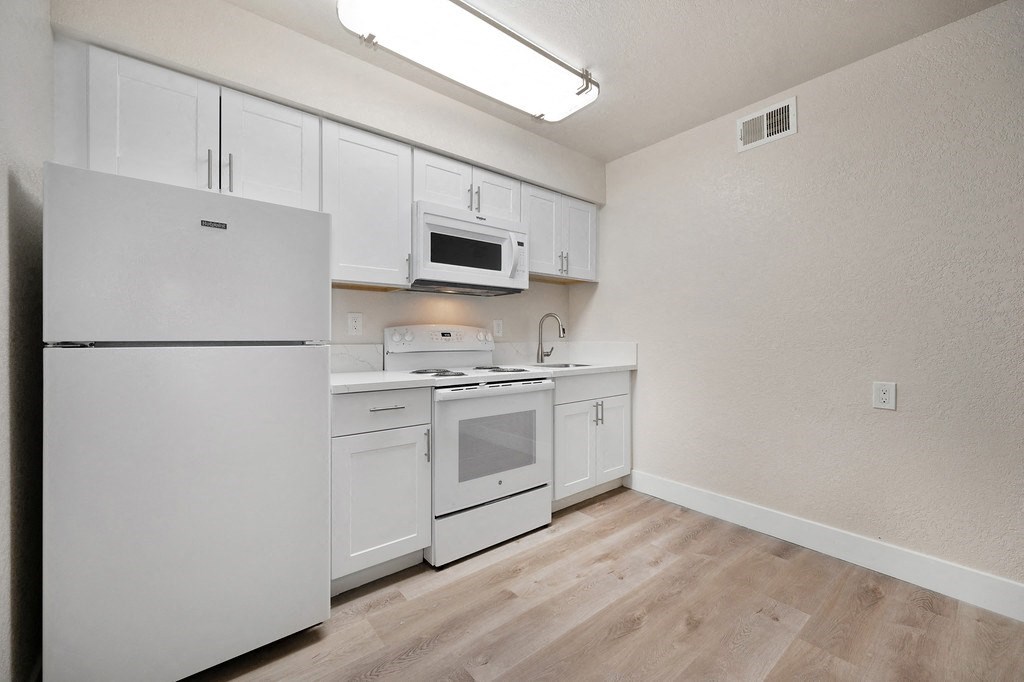 a kitchen with white cabinets and white appliances