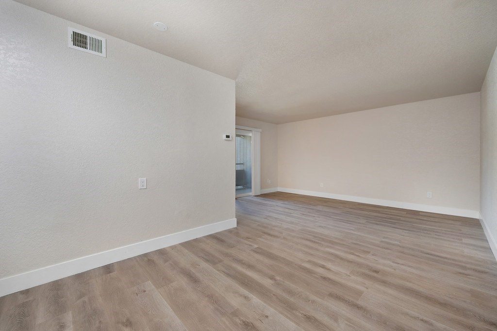 a bedroom with hardwood floors and white walls