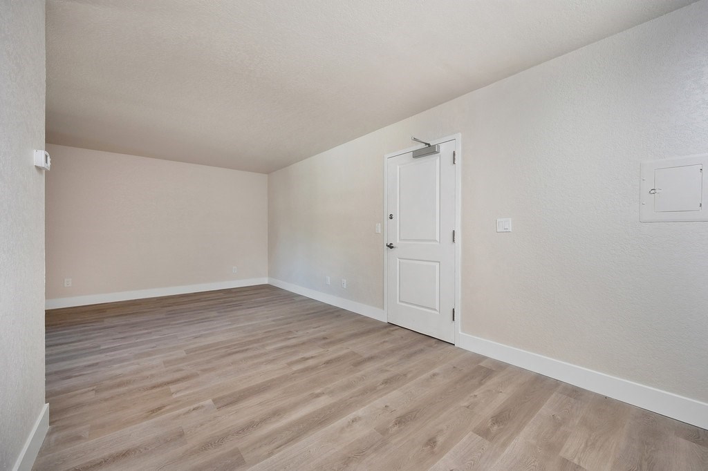 a bedroom with hardwood floors and white walls