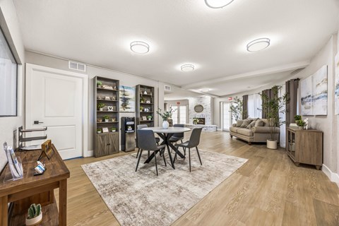 A well-lit living room with a dining table and chairs in the center.