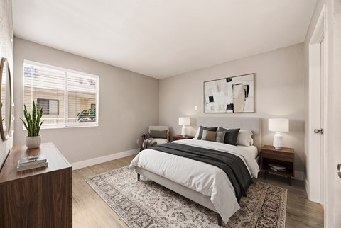 A bedroom with a large bed and a mirror on the wall.