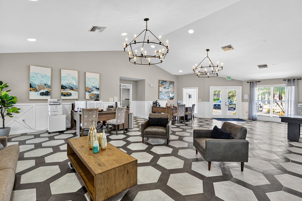 A spacious living room with a patterned floor and a large chandelier.