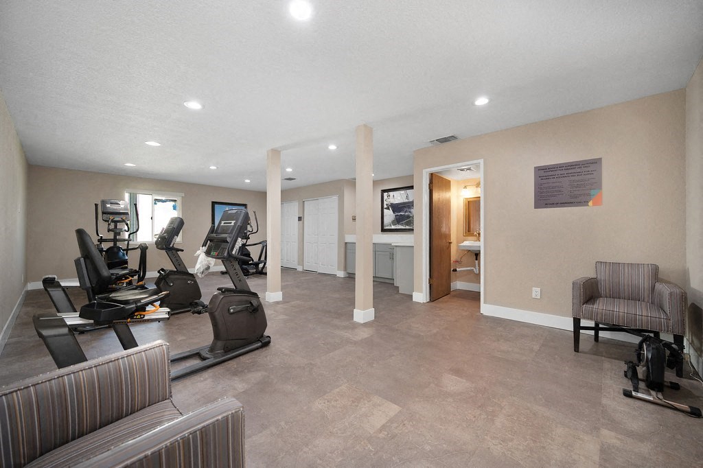 a spacious fitness room with treadmills and elliptical trainers