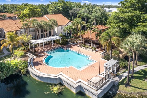 A large swimming pool surrounded by a deck and a covered patio area.