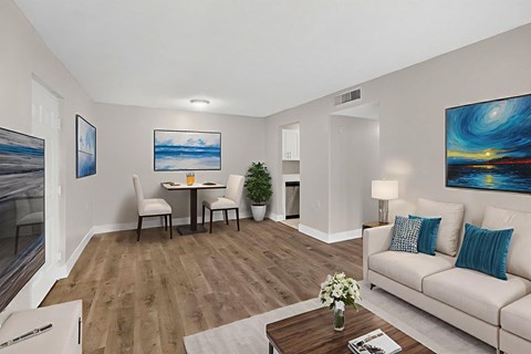 A living room with a white couch, a coffee table, and a painting on the wall.