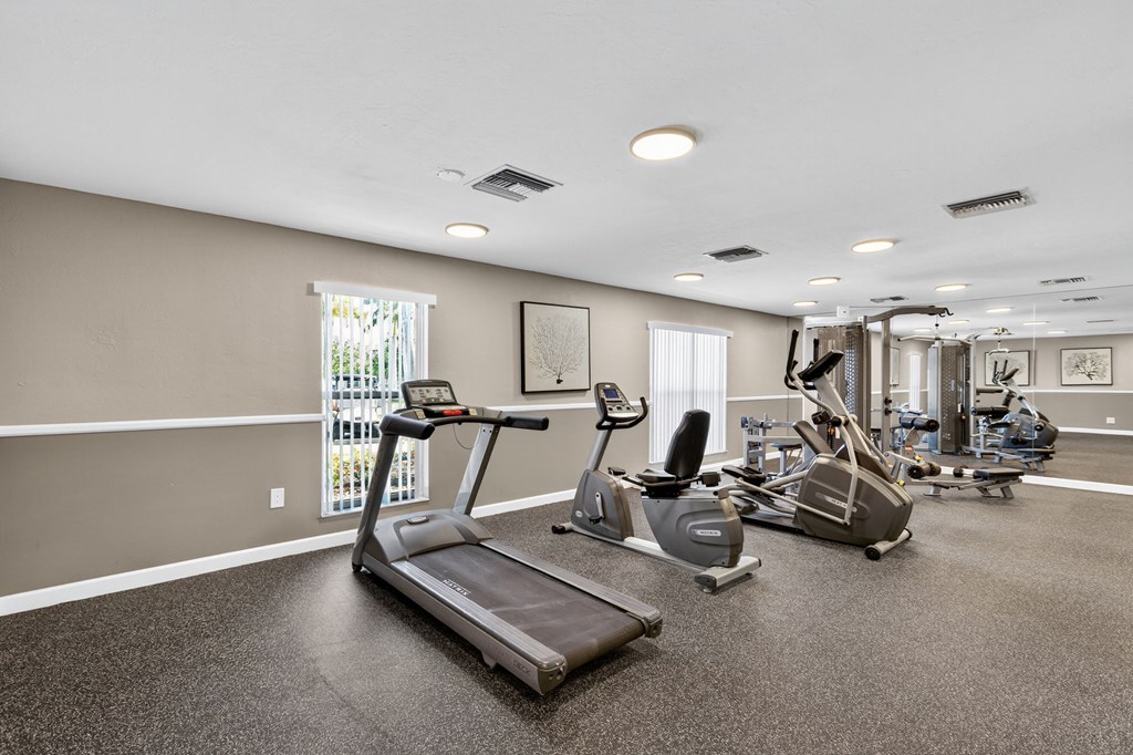 A spacious gym with treadmills, elliptical machines, and other exercise equipment.
