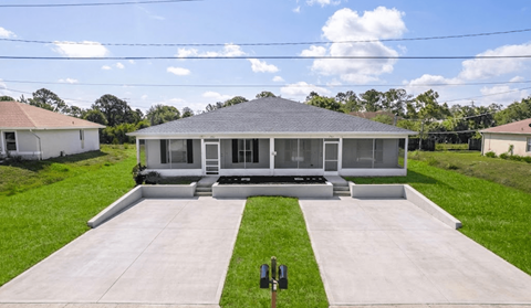 A house with a grey roof and a white fence.
