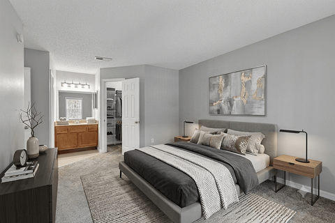 A bedroom with a large bed and a painting on the wall.