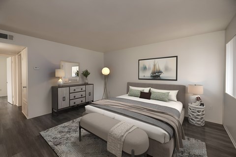 A bedroom with a bed, nightstands, and a painting on the wall.