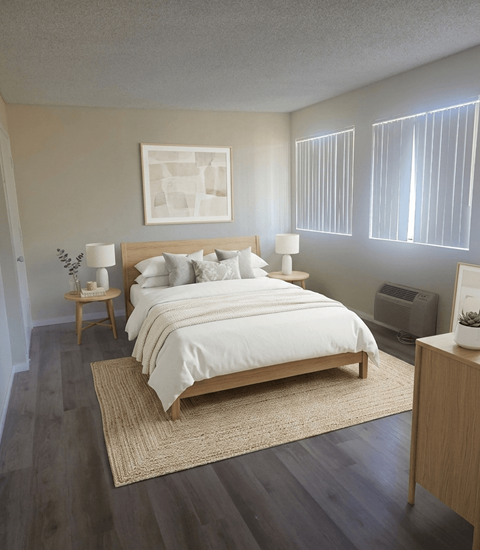 A bedroom with a large bed and a nightstand with a lamp.