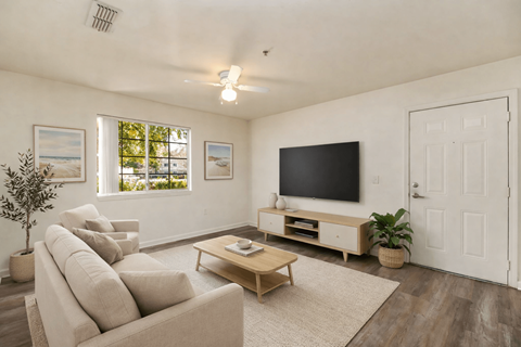 A living room with a large couch, a coffee table, and a flat screen TV.