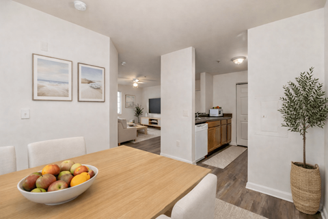 A dining room with a bowl of fruit on the table.