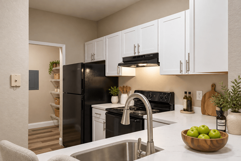 A kitchen with a black refrigerator and white cabinets.