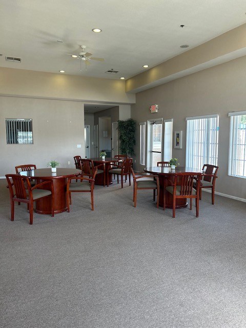 A room with a dining table and chairs.