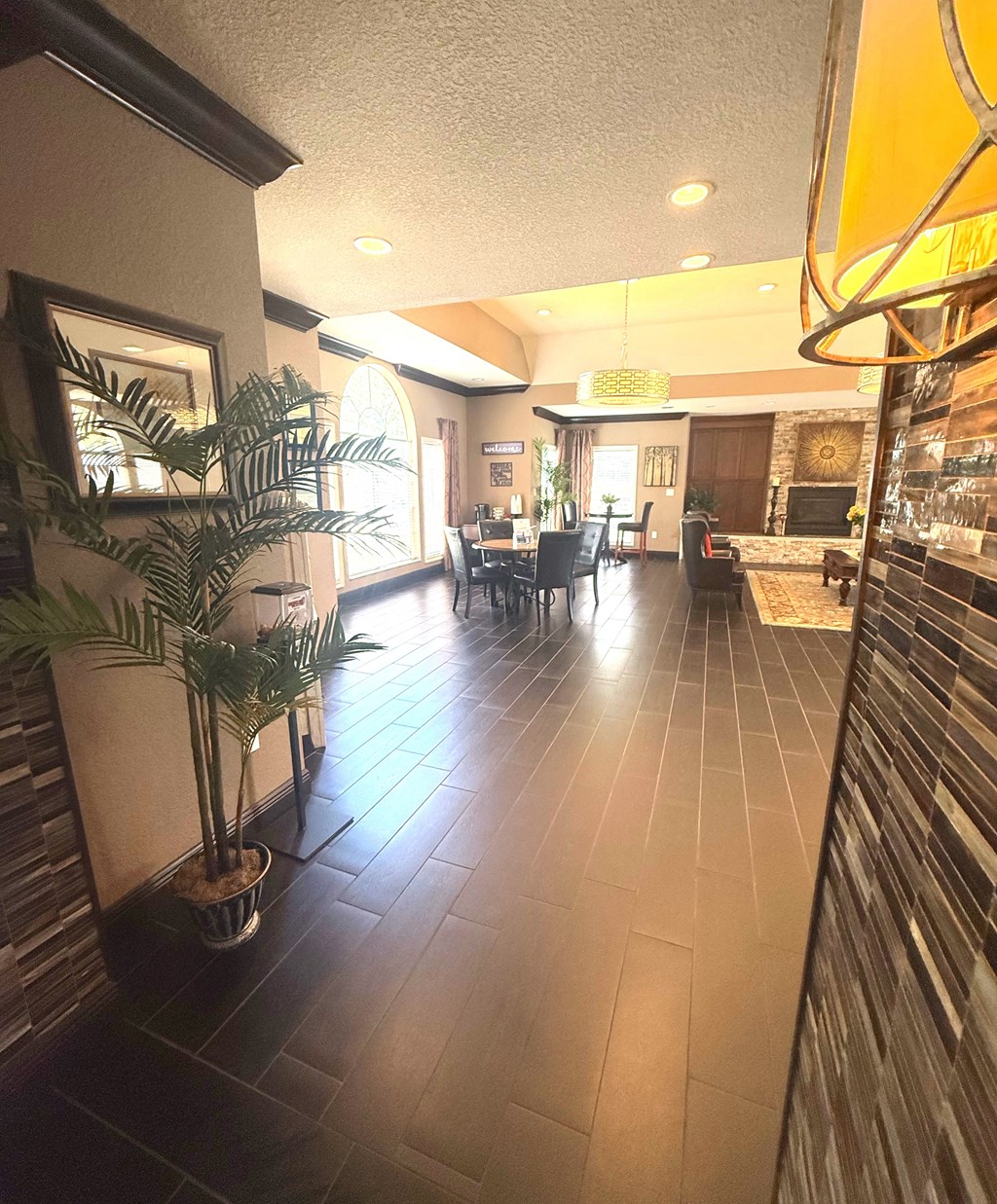 A long hallway with a plant on the left and a bar on the right.