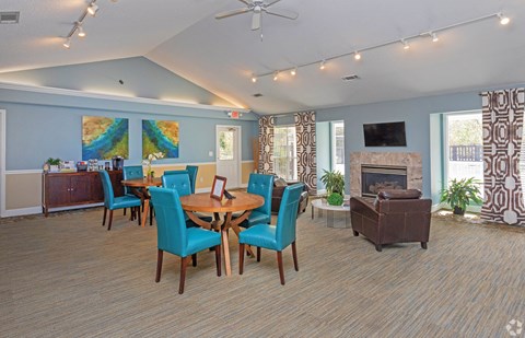 a living room with a table and chairs and a fireplace