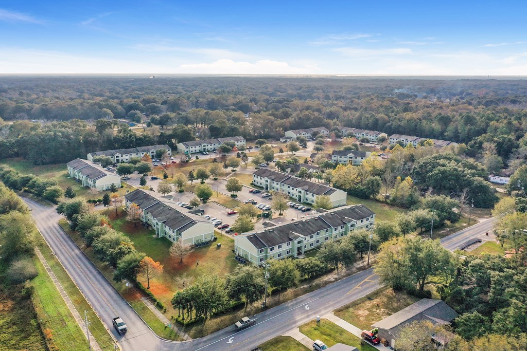A bird's eye view of a residential area with multiple houses and a road.