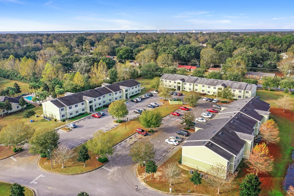 A large building complex with a parking lot in front.