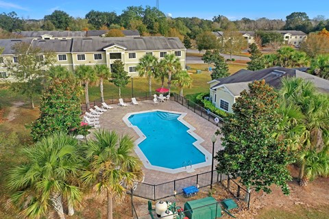 A pool surrounded by a fence and trees.