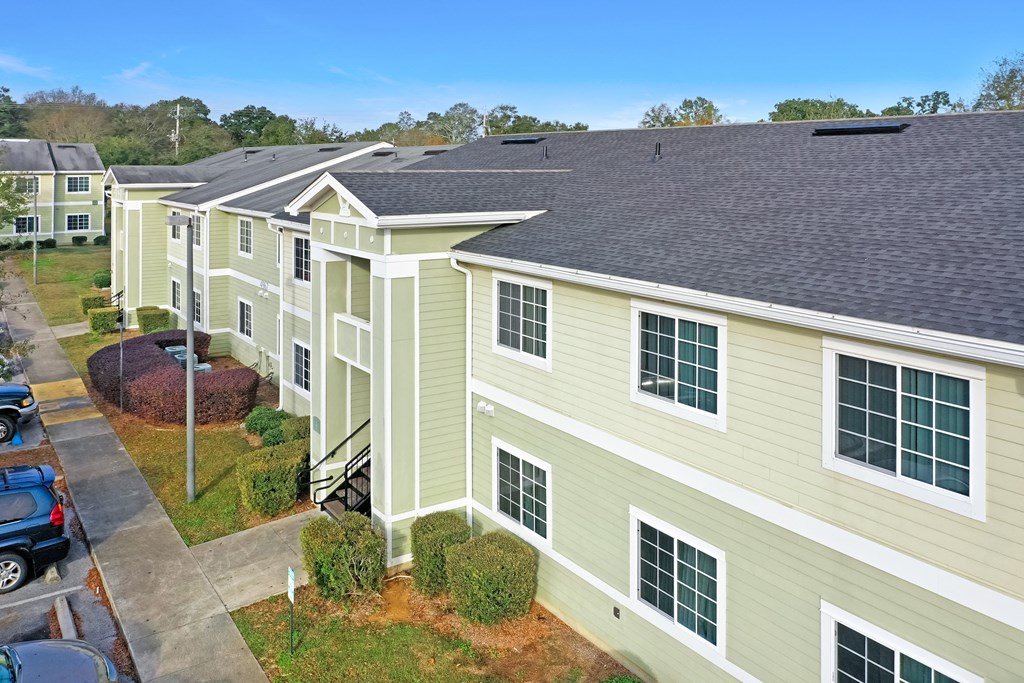 A row of houses with green siding and white trim.