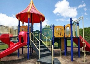 A playground with a red slide and a yellow and blue structure.