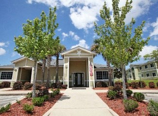 A building with a flag on the front and trees in front.