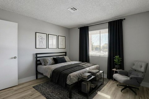 A bedroom with a bed, chair, and two pictures on the wall.