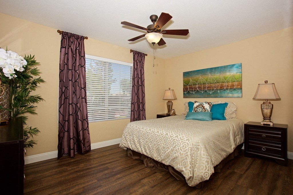 a bedroom with a bed and a ceiling fan