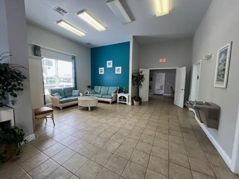 A spacious waiting room with a fireplace, couches, and a plant.