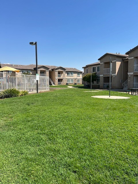 A grassy area in front of apartment buildings.