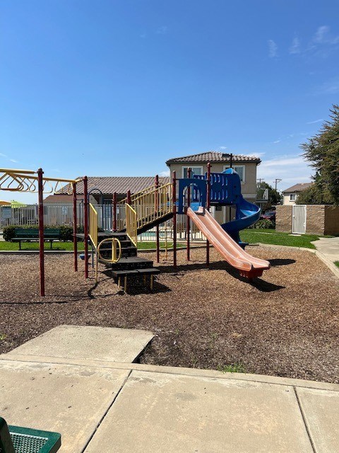 A playground with a blue slide and a red slide.